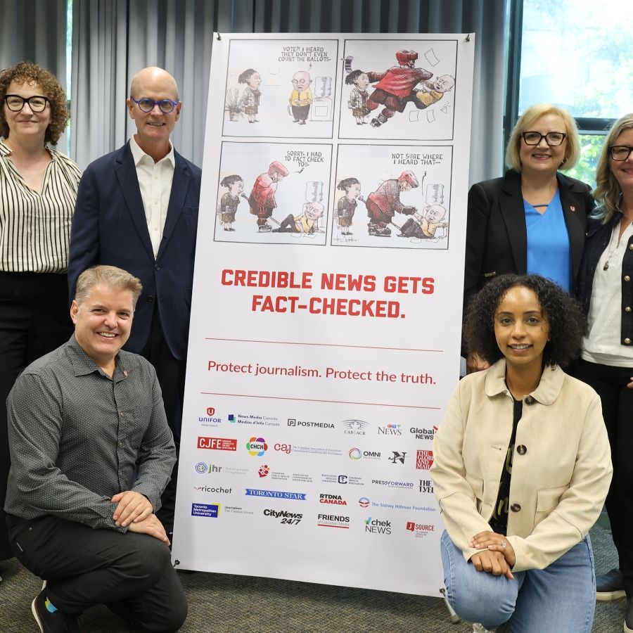 six people standing beside a x-stand banner.