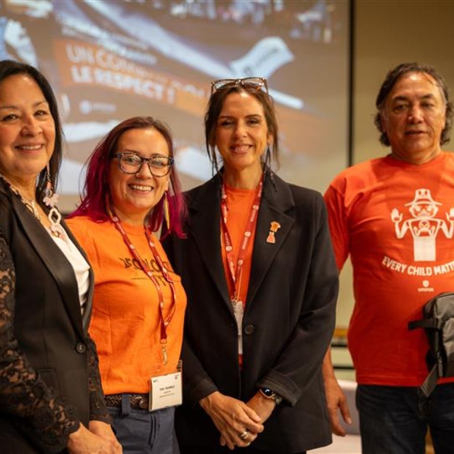 Four people wearing orange shirts