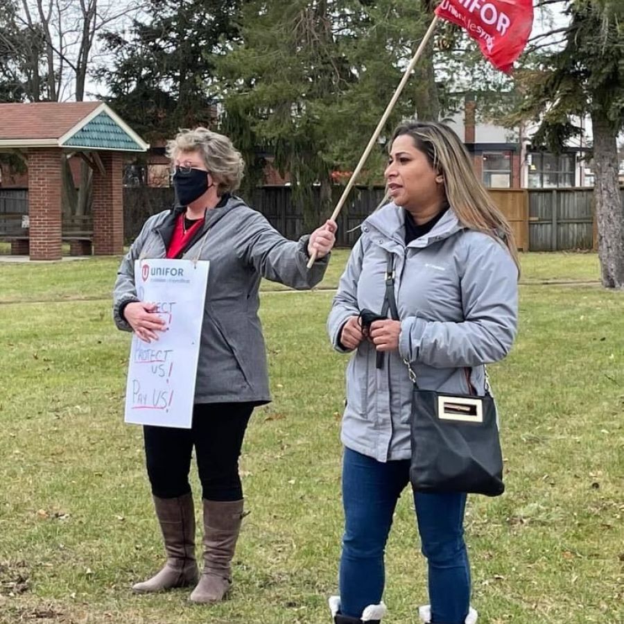 Naureen Rizvi Stans with a member holding a picket sign and Unifor flag