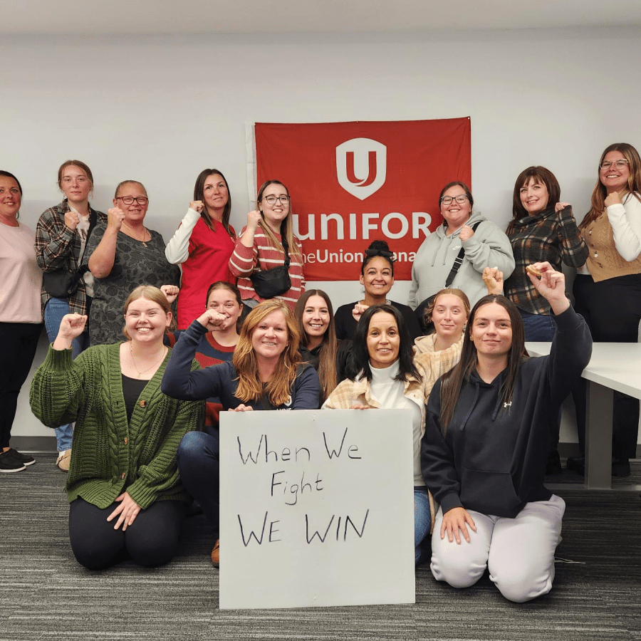 A group of women posing with a sign that reads, When we fight, we win!
