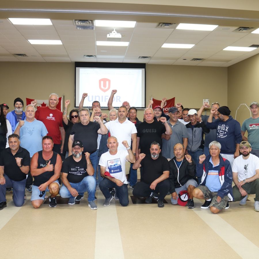 A large group in a conference room two rows first is kneeling 